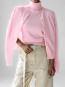 Rosa Strick-Rollkragenweste kombiniert mit passendem Cardigan und beiger Hose Set.