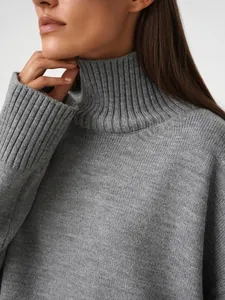 Primo piano che mostra la trama del morbido maglione grigio a dolcevita per donna