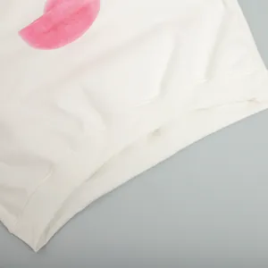 Dettaglio macro della felpa bianca a girocollo con stampa rosa e orlo a costine elasticizzato
