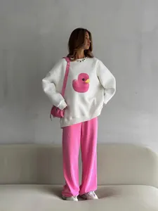 Modella che indossa una felpa girocollo bianca oversize con stampa di anatra rosa