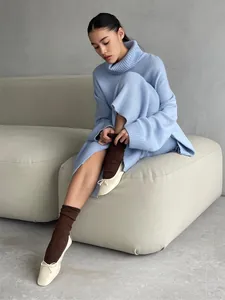 Oversized blue turtleneck sweater and knit skirt set with model on minimalist background