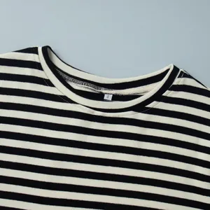 Detail van de ronde hals van een zwart-wit gestreept katoenen shirt met lange mouwen