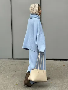 Chic oversized light blue turtleneck sweater and matching knit skirt set for winter