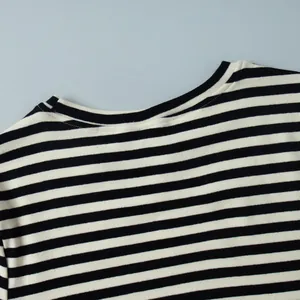 Detailopname van de halslijn en stof van een gestreept zwart-wit katoenen T-shirt