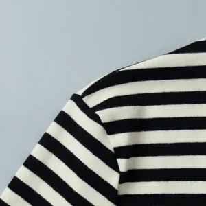 Gedetailleerde close-up van de schoudernaad op een zwart-wit horizontaal gestreept shirt