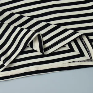 Detailopname van de hoogwaardige zoomstiksels van een zwart-wit gestreept katoenen T-shirt