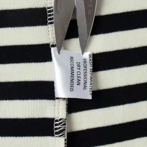 Detail van het waslabel op een premium zwart-wit gestreept katoenen T-shirt voor dames