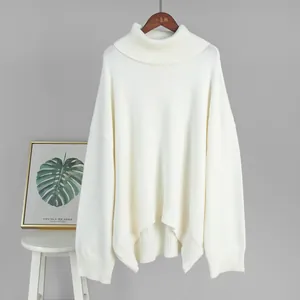 Front view of white oversized turtleneck knit sweater hanging against a gray background