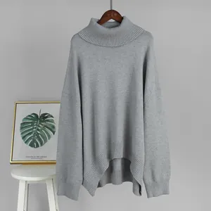 Close-up of a grey oversized turtleneck sweater with a ribbed high-low hemline.