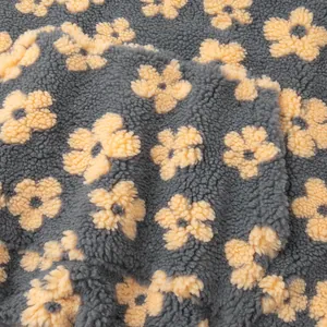 Macro view of soft grey fleece fabric with yellow flower pattern detail