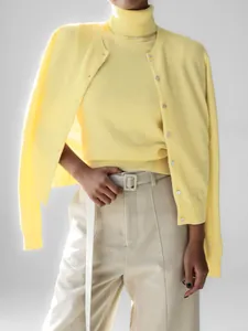 Detailaufnahme eines eleganten gelben Strickoberteils mit passender Strickjacke