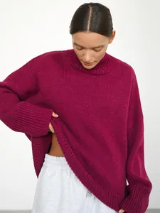 Dettaglio maglione oversize fucsia in maglia con collo alto e polsini a costine.