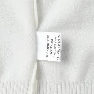 Macro view of the professional dry clean care label on a soft white knitted sweater
