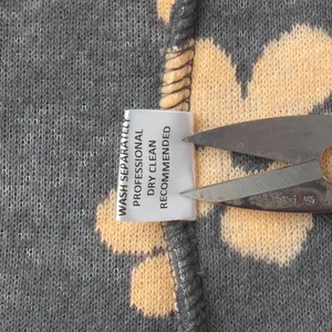 Close-up of the wash label on a floral fleece sweatshirt showing professional care instructions