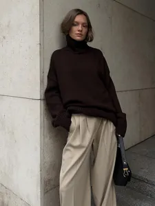 Stile street chic con una donna che indossa un maglione marrone a collo alto oversize