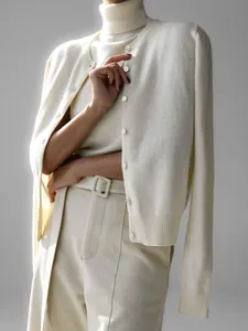 Detail view of ivory turtleneck and cardigan knitwear set showing soft texture.