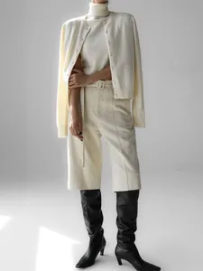 Professional detail shot of an elegant cream knit set featuring a turtleneck top and cardigan.