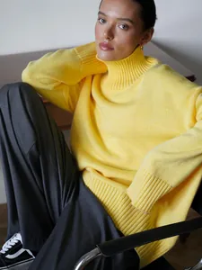 Dettaglio di un maglione a collo alto in maglia giallo brillante con colletto a coste.