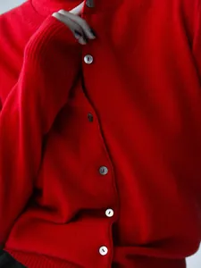 Close-up detail of red knit cardigan sweater featuring stylish round buttons