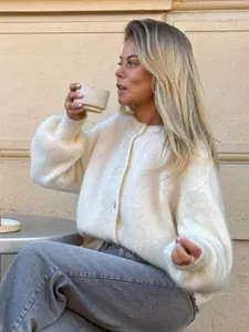 Detailansicht eines weißen Mohair-Cardigans mit flauschiger Textur und einreihiger Knopfleiste.