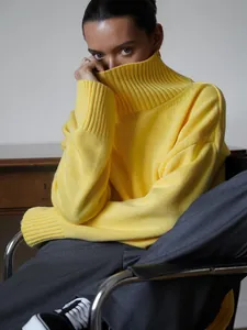 Primo piano di un maglione a dolcevita in maglia grossa giallo acceso indossato da modella