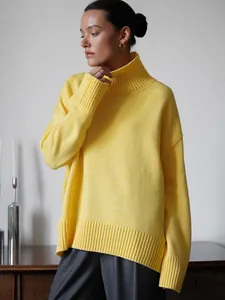 Primo piano della trama a coste e della vestibilità di un maglione giallo a collo alto