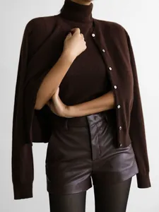 Close-up of a dark brown knitwear set featuring a turtleneck top and matching cardigan.