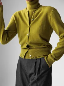 Detailed view of chartreuse knit set featuring a high-neck top and buttoned cardigan.