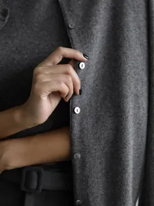 Macro view showing the soft texture and button detail of this dark grey knit cardigan set