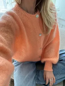 Nahaufnahme der flauschigen Textur dieser orangefarbenen Strickjacke für Damen