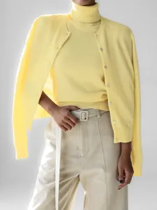 Detailed view of yellow knitwear set featuring sleeveless turtleneck and matching cardigan