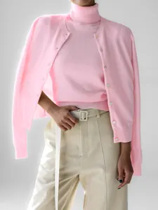 Close-up of pink turtleneck knit top paired with a matching buttoned cardigan set