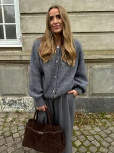 Frau in grauer einreihiger Strickjacke mit Puffärmeln für den herbstlichen Mode-Look.