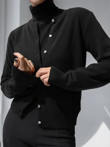 Detail shot of black knit two-piece set featuring turtleneck top and elegant button-up cardigan