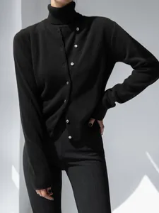 Close-up detail of the black knitted cardigan and high neck sleeveless top set.