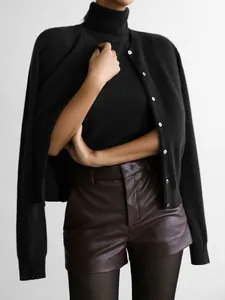 Elegant black two-piece knitwear set featuring turtleneck tank top and soft button cardigan