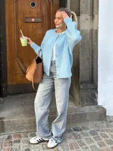 Stilvolle Frau trägt eine süße babyblaue Strickjacke mit einreihiger Knopfleiste