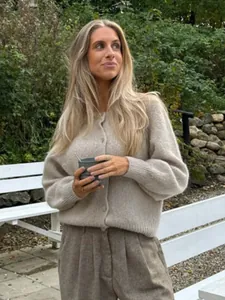 Stilvolle Frau in gemütlicher haferfarbener Strickjacke mit Knöpfen im Freien