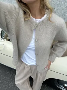 Detailaufnahme eines weichen beigen Strick-Cardigans mit stilvollen einreihigen Perlmuttknöpfen.