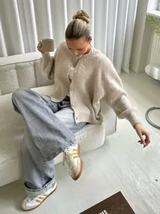 Gemütliche beige Strickjacke für Damen in einer modernen, minimalistischen Wohnung
