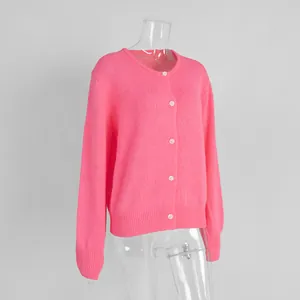 Detail einer pinken, einreihig geknöpften Strickjacke mit weißen Knöpfen auf einer Schaufensterpuppe.