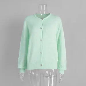 Detailansicht einer minzgrünen Strickjacke mit Silberknöpfen auf einer Schaufensterpuppe.