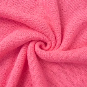 Makroansicht der weichen Textur und Webart einer bonbonrosa gestrickten Strickjacke