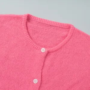 Detaillierte Ansicht der pinken Strickjacke mit Fokus auf Kragen und weiße Knöpfe