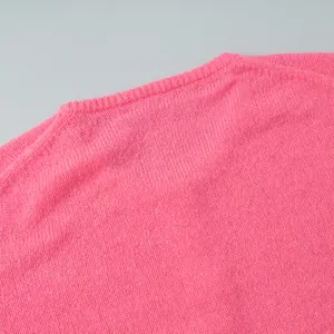Nahaufnahme der Stricktextur und des gerippten Ausschnitts bei einem pinkfarbenen Pullover