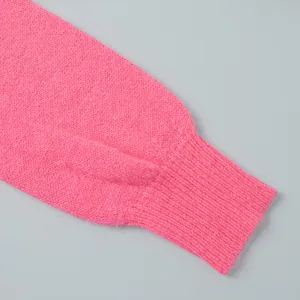 Makro-Detail der gerippten Manschette und weichen Strickstruktur eines rosa Cardigans