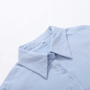 Dettaglio del colletto di una camicia in cotone stropicciato azzurro con etichetta taglia M