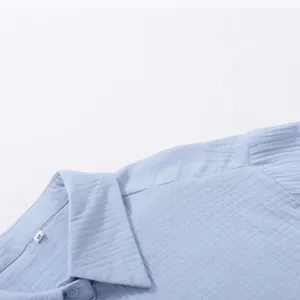 Dettaglio del colletto di una camicia di cotone stropicciato azzurro con tag M.