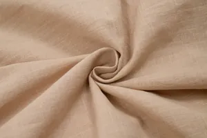 Detailed macro shot of beige pure cotton dress fabric showing natural texture weave