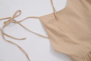 Macro view of a beige pure cotton camisole dress featuring elegant tie-up shoulder straps